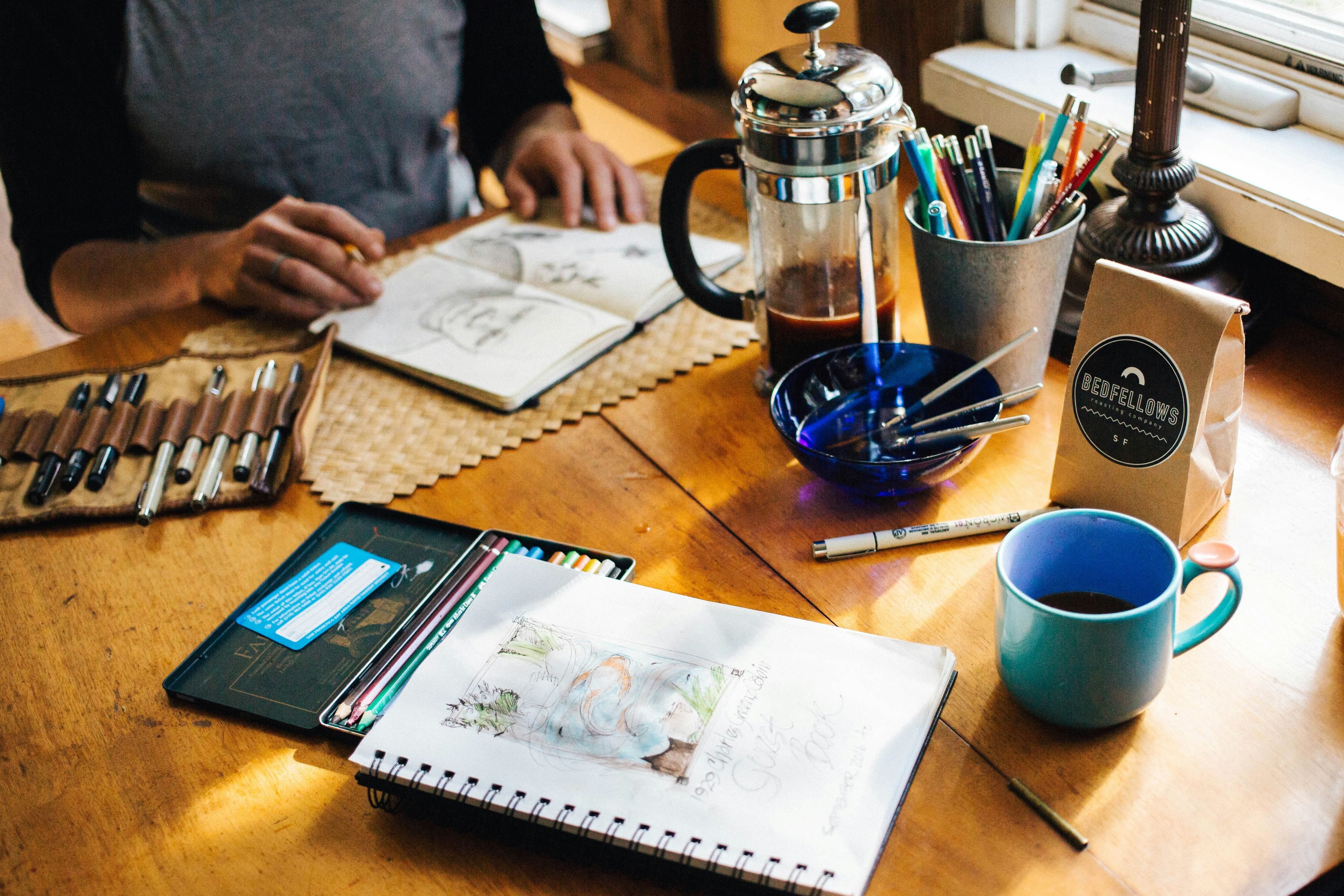 Sketchbooks on table with coffee